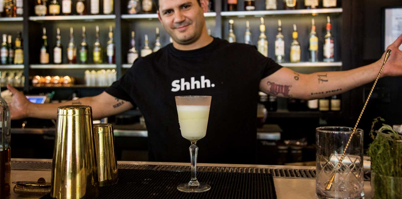 A bartender at The Grove upstairs from Secret Sandwich Society in Fayetteville, West Virginia, presents a freshly mixed drink on the bar.