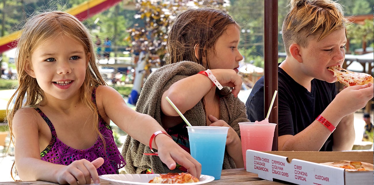 Kids pizza party with fruit slushies on the patio umbrella deck at Wonderland Waterpark at ACE Adventure Resort.