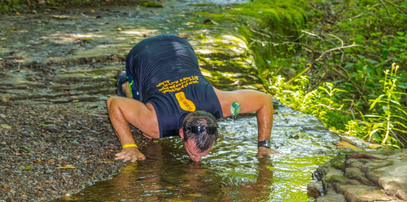 A runner competing in the Wonderland Mountain Challenge takes a drink from the spring on the trail at ACE Adventure Resort.