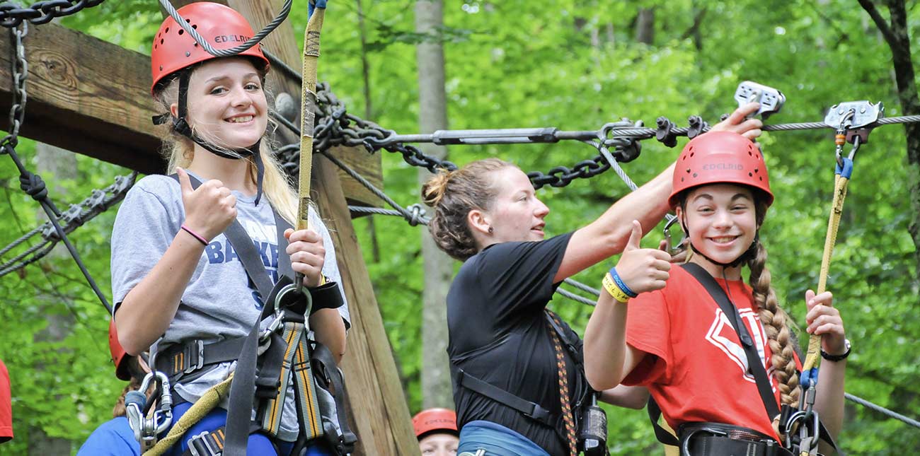 A group of girls on a school trip with ACE get clipped into the ziplines, and prepare to take off on a cliffside zip trip at ACE Adventure Resort.