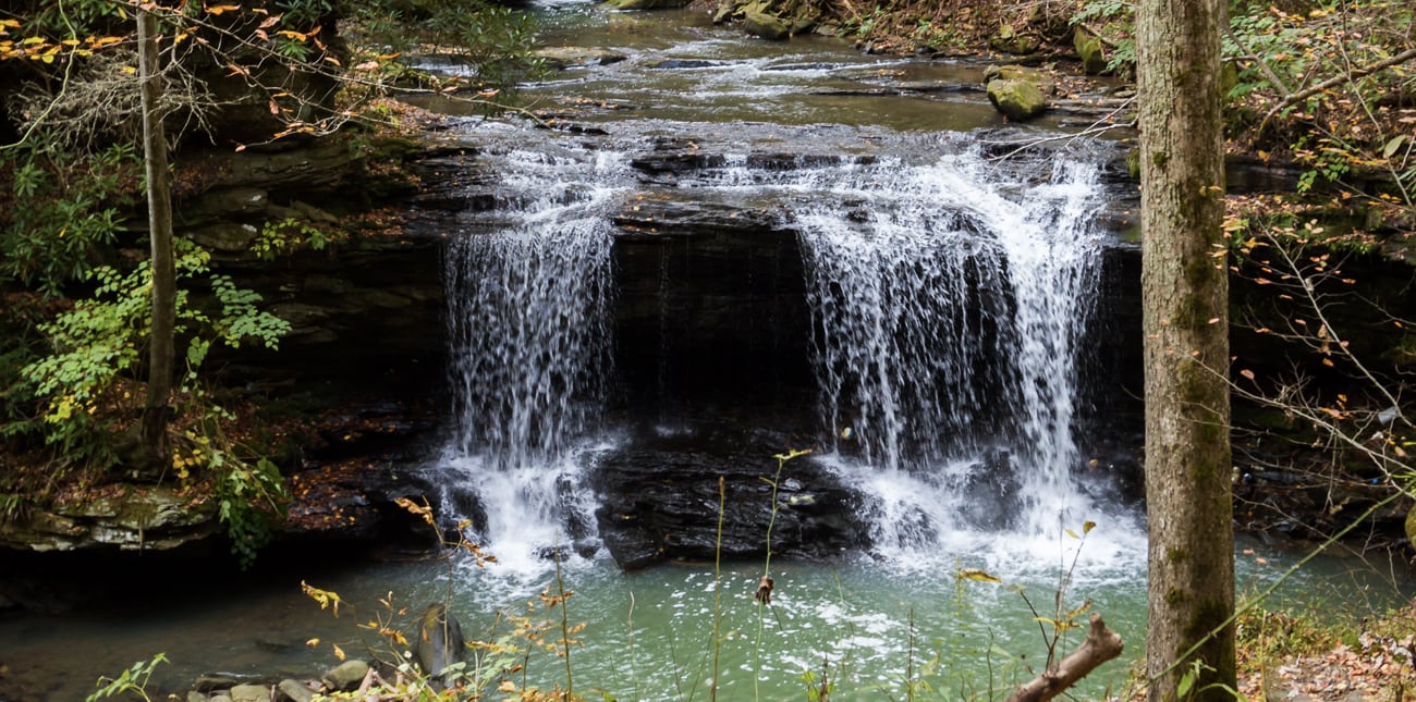 A waterfall along a hiking trail at ACE Adventure Resort pours into the creek.