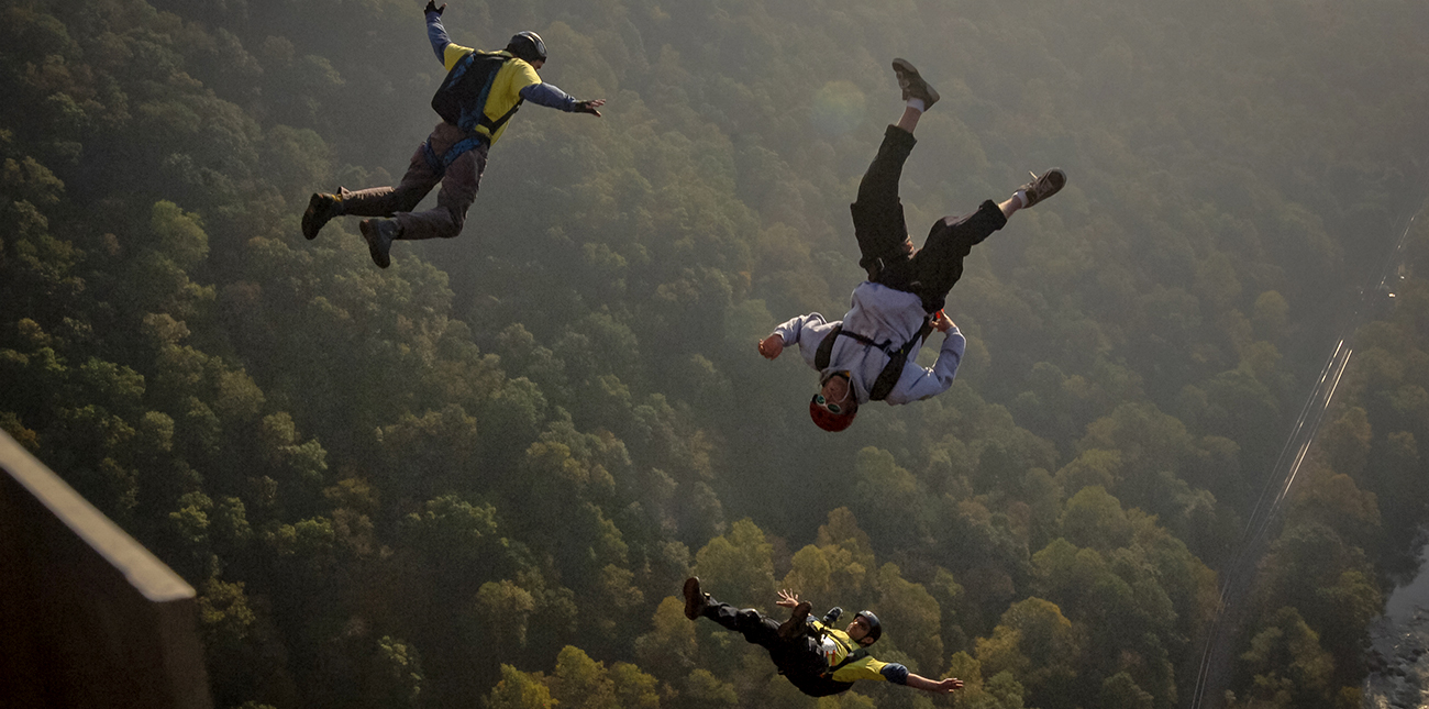 Participants of Bridge Day BASE jump from the New River Bridge into the Gorge.