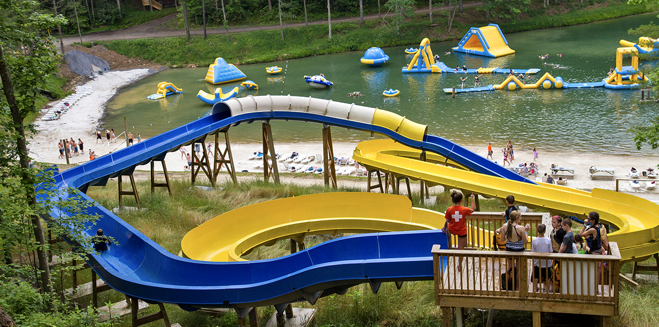 Two waterslides overlook ACE lake and the beach at wonderland waterpark at ACE Adventure Resort, open during the 2019 GIRL Fest in the New River Gorge.