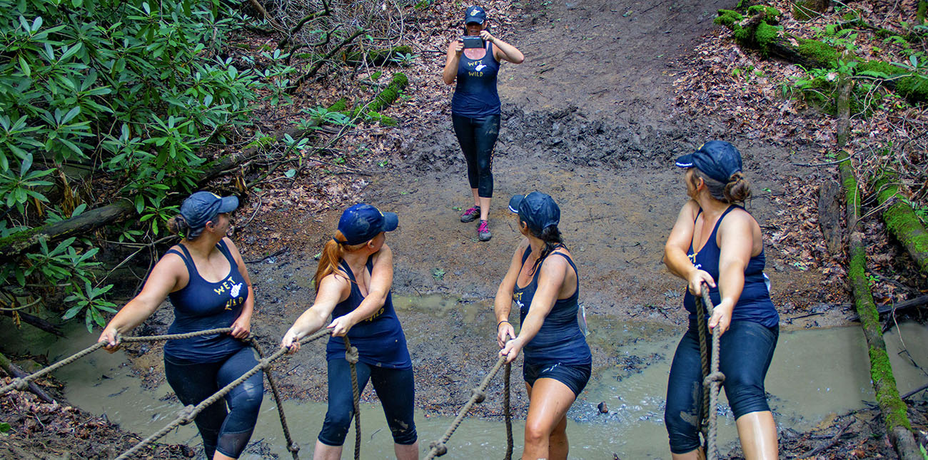 Athletes pose for a photo at the wall climb during the 2018 Gritty Chix Mud Run at ACE Adventure Resort.