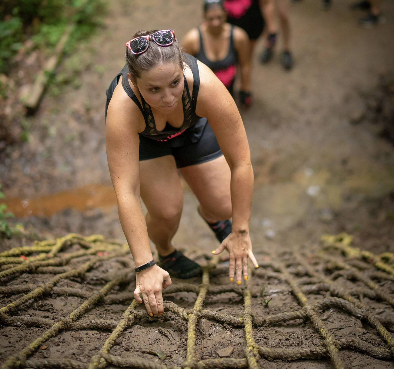 A woman climbs the rope ladder during the 2018 Gritty Chix Mud Run at ACE Adventure Resort in Southern WV.