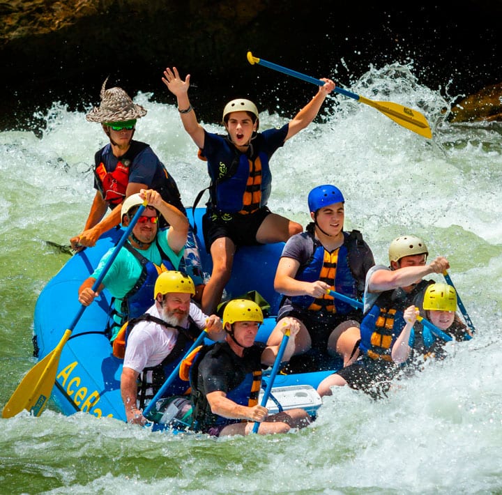 A closeup of smiling friends on a lower new river gorge white water rafting trip running lower keeney rapid in the new river gorge national park.