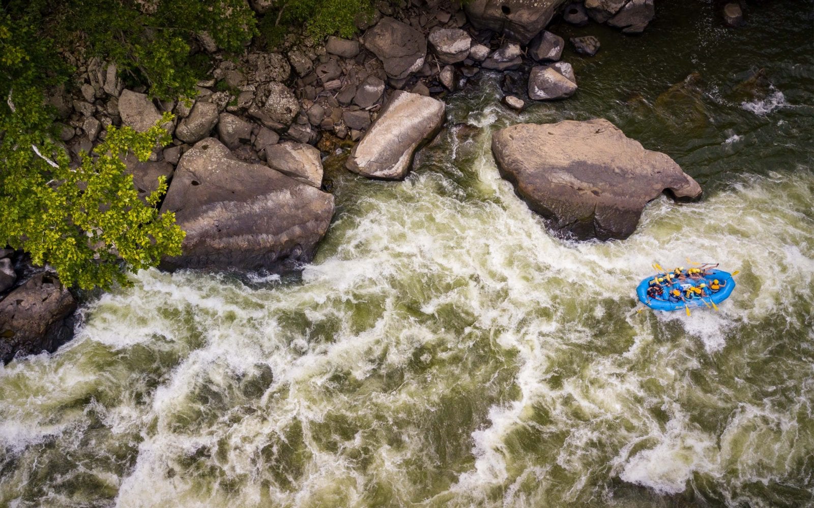 A west virginia whitewater rafting rafting aerial shot of a blue boat running Lower Keeney rapid.