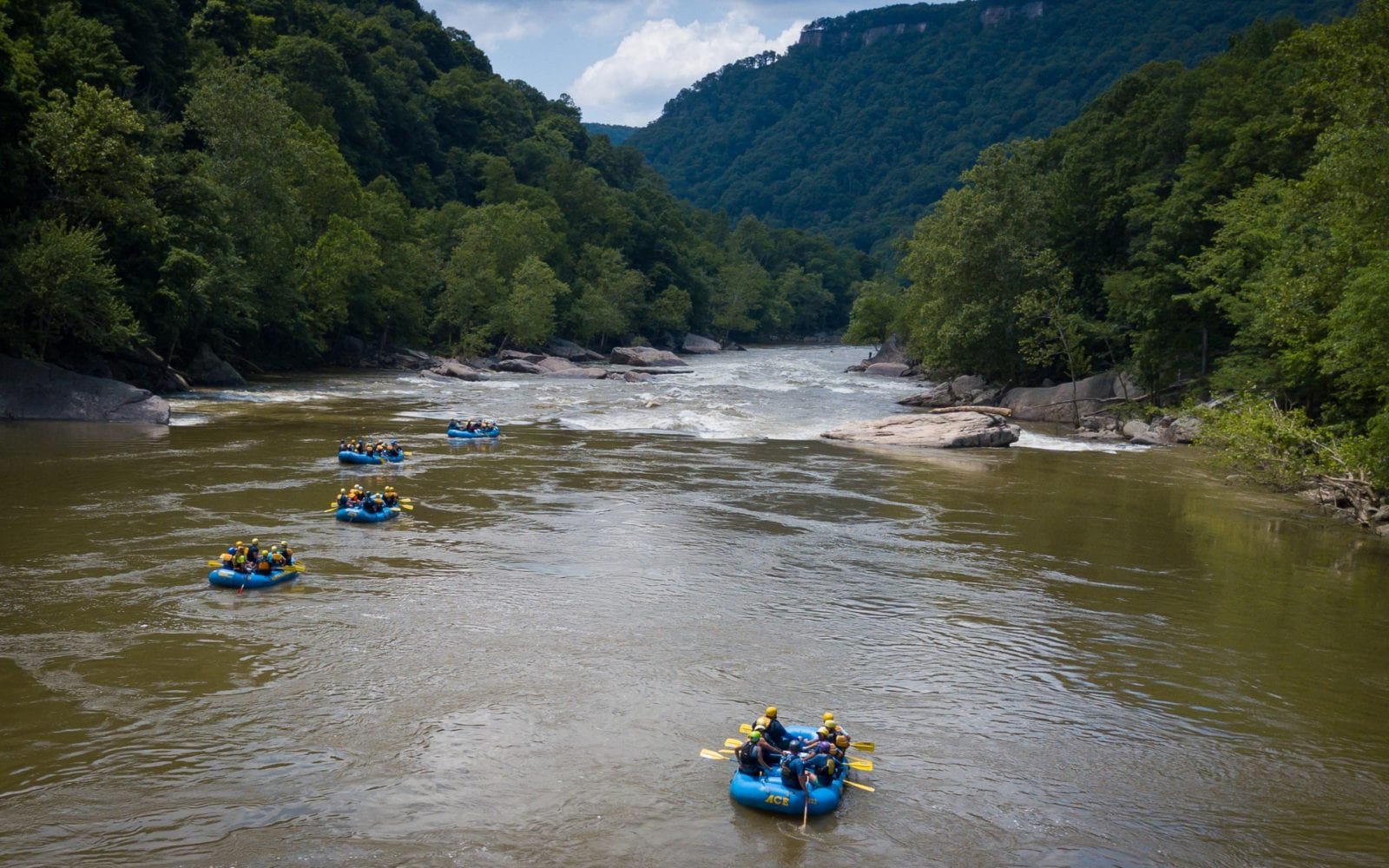 A spring shot of rafts entering high waters on the New River Gorge in West virginia whitewater rafting.