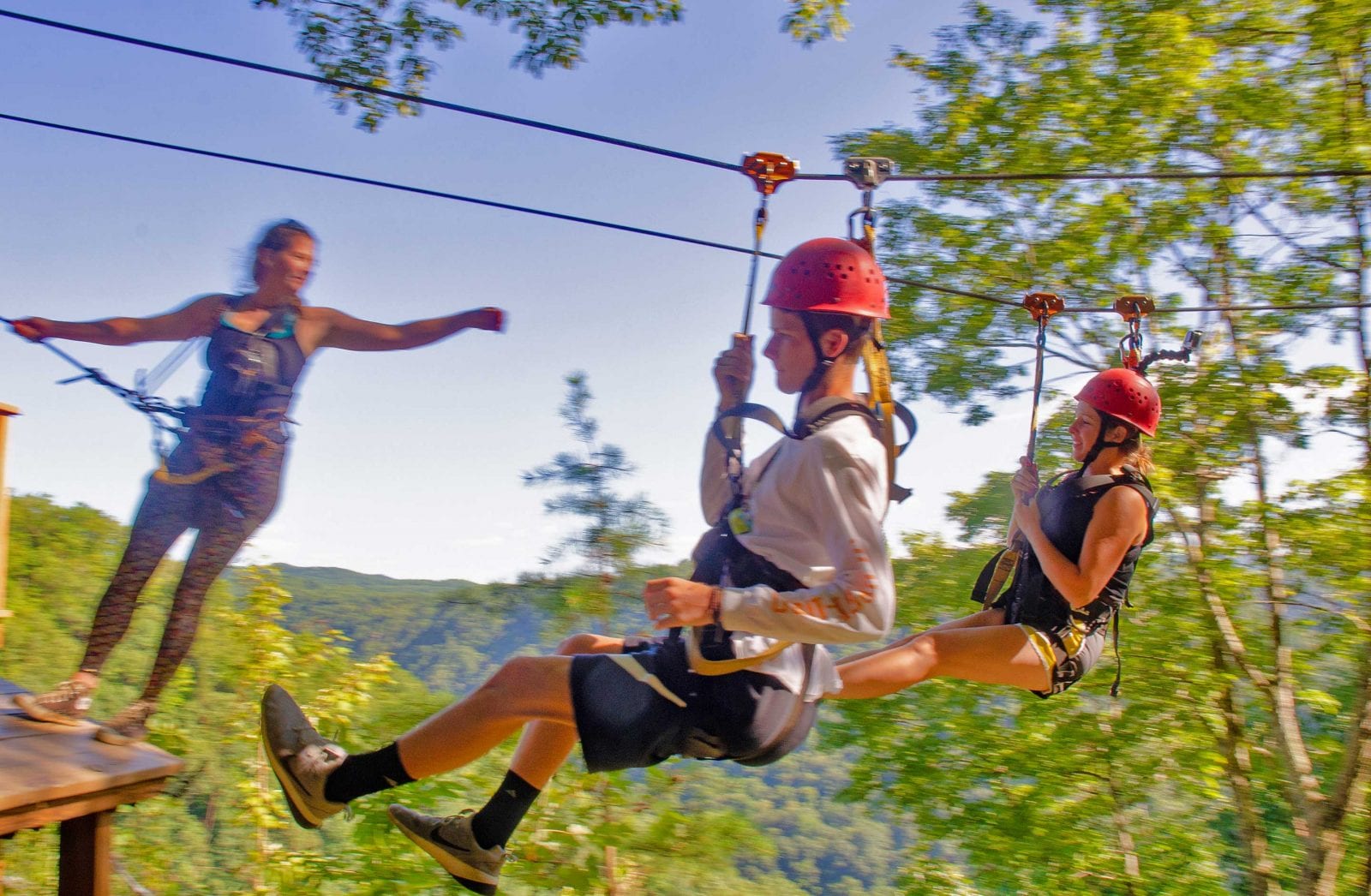 A mother and son enjoy come into a landing on ACE's New River Gorge ziplining canopy tour.