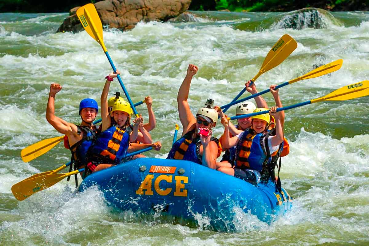 Guests smile and laugh while rafting the Lower New River Gorge in West Virginia.