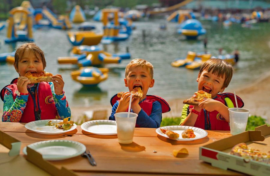 youth groups Kids eating pizza in front of waterpark 