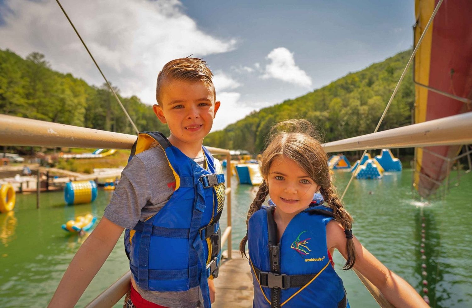 A young brother and sister smile from the water park tower at ace adventure resort in west virginia. ACE is one of the best summer camps in West Virginia!