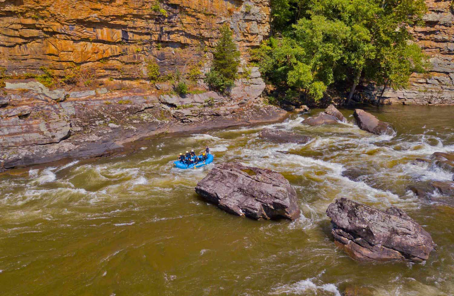 A lower gauley river rafting trip passes the cliffs of canyon doors rapid.