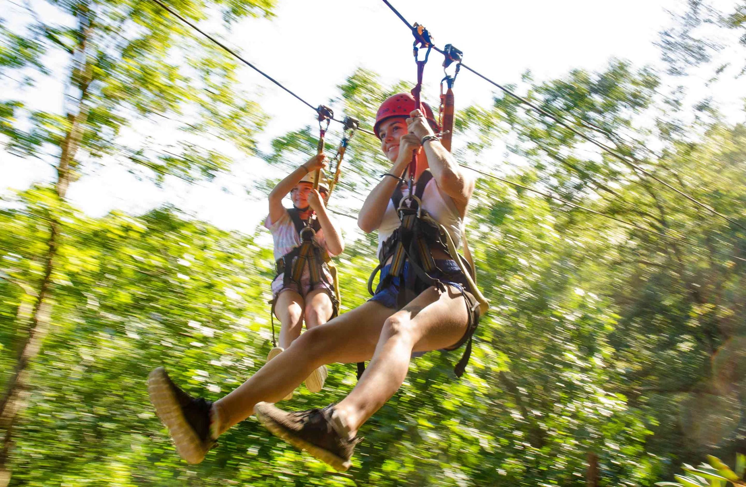 Two friends enjoy ziplining in the New River Gorge of West Virginia at ACE Adventure Resort.