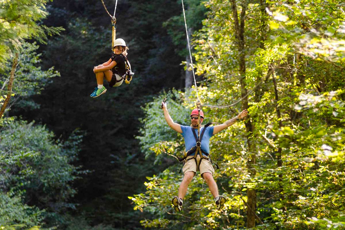 A Father and daughter enjoy a tandem zip lining tour beside the New River Gorge of West Virginia.