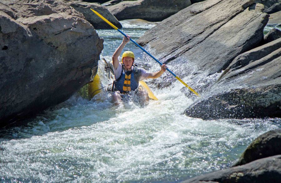 An ACE guest paddles the Summer Gauley rapids in an inflatable kayak.