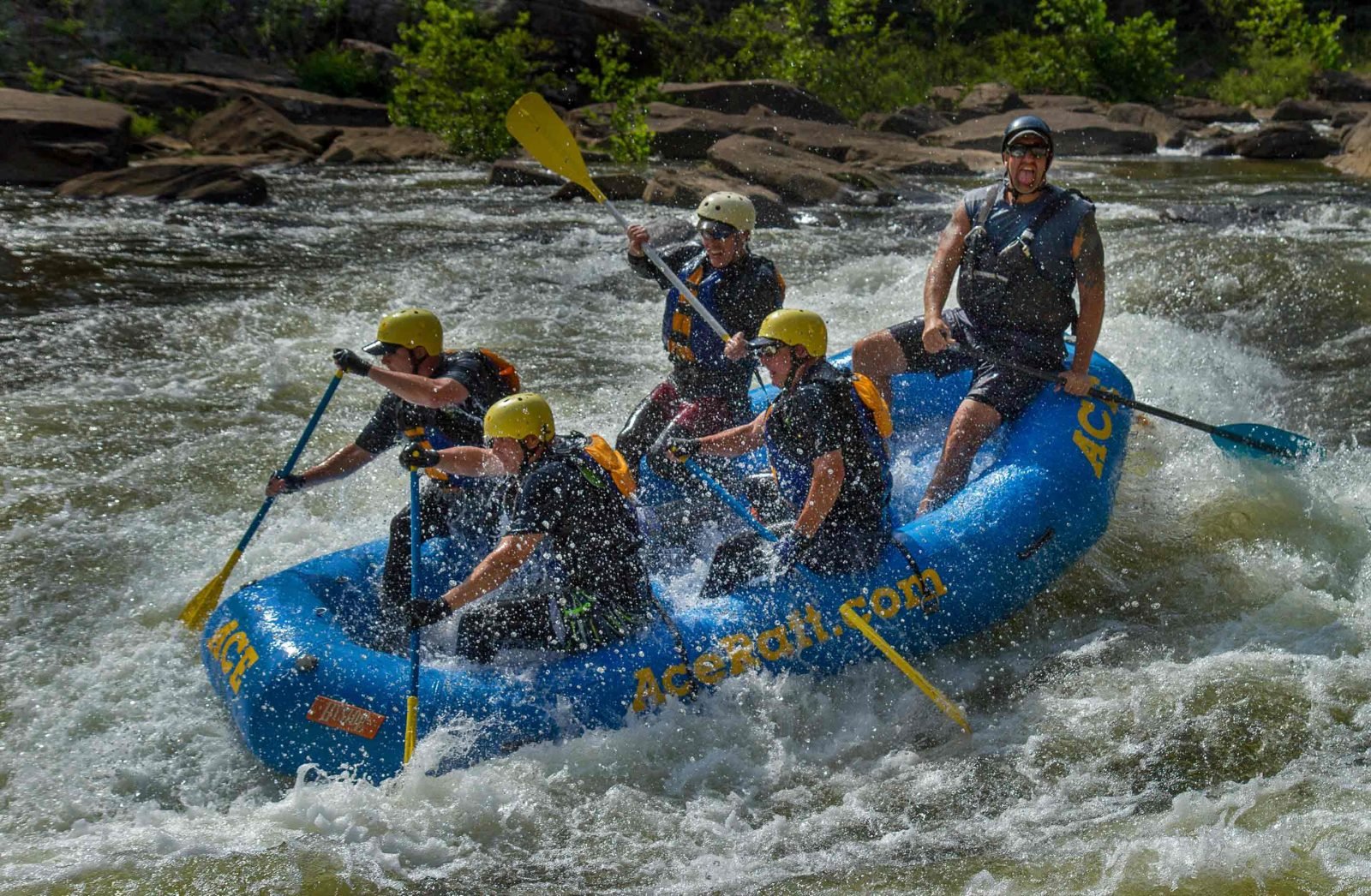 A group of four guests enjoy big hits in a small raft on the Lower Gauley River whitewater rafting with ACE Adventure Resort in West Virginia.