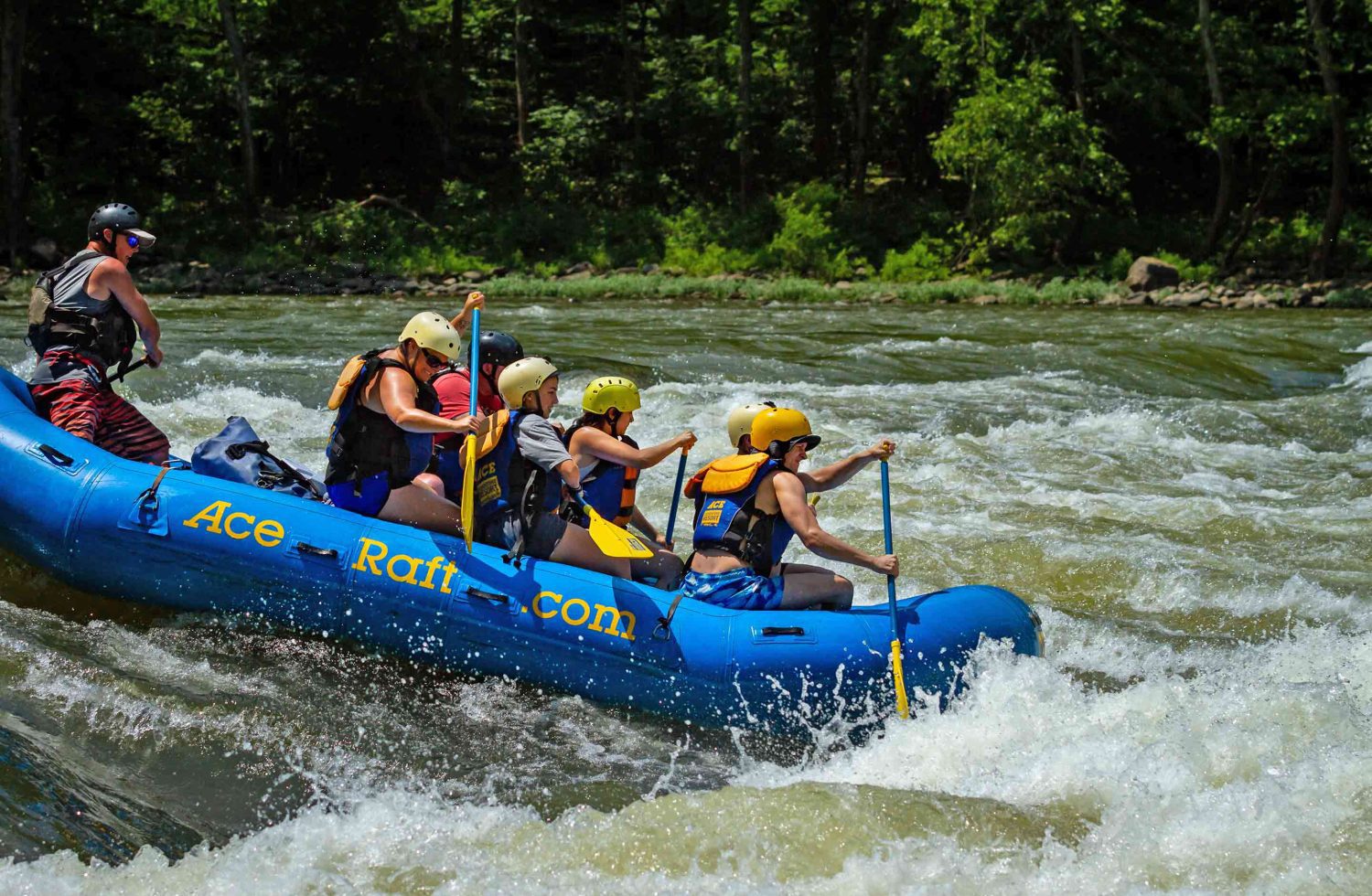 A side view of a rafting running Upper Railroad rapid during a New River Gorge white water rafting trip in West Virginia.