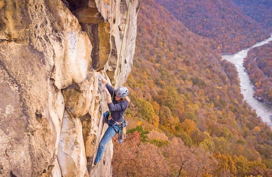 A climber ascends the cliffs on the New River Gorge on a rock climbing trip with ACE Adventure Resort.