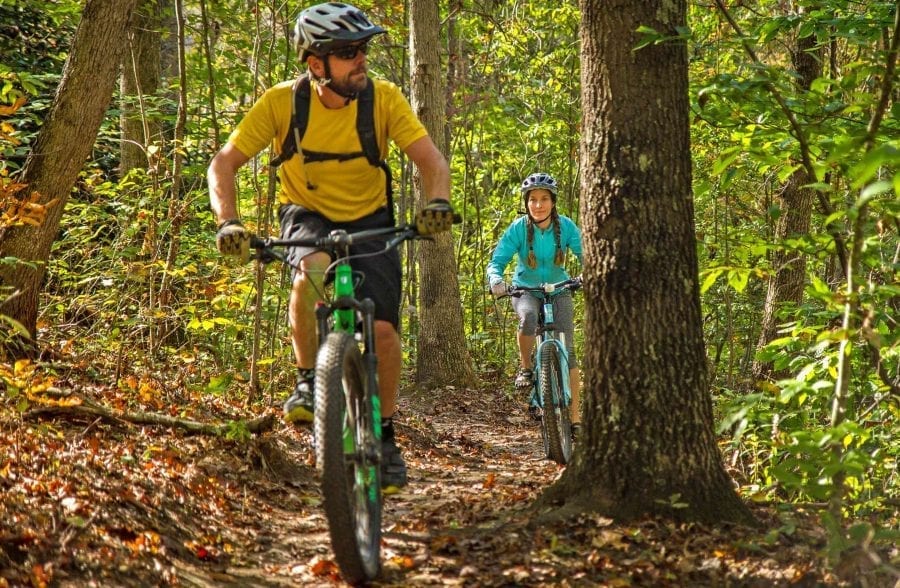 A couple goes mountain biking in the fall on New River Gorge trails with ACE Adventure Resort in West Virginia.