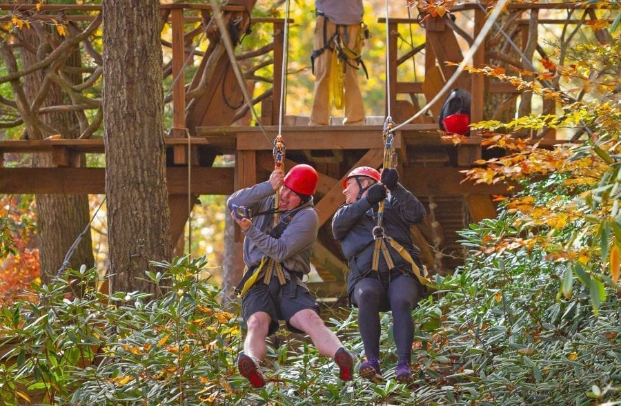 A couple rides the zip line together on an adventure activity date with ACE in the New River Gorge, West Virginia.