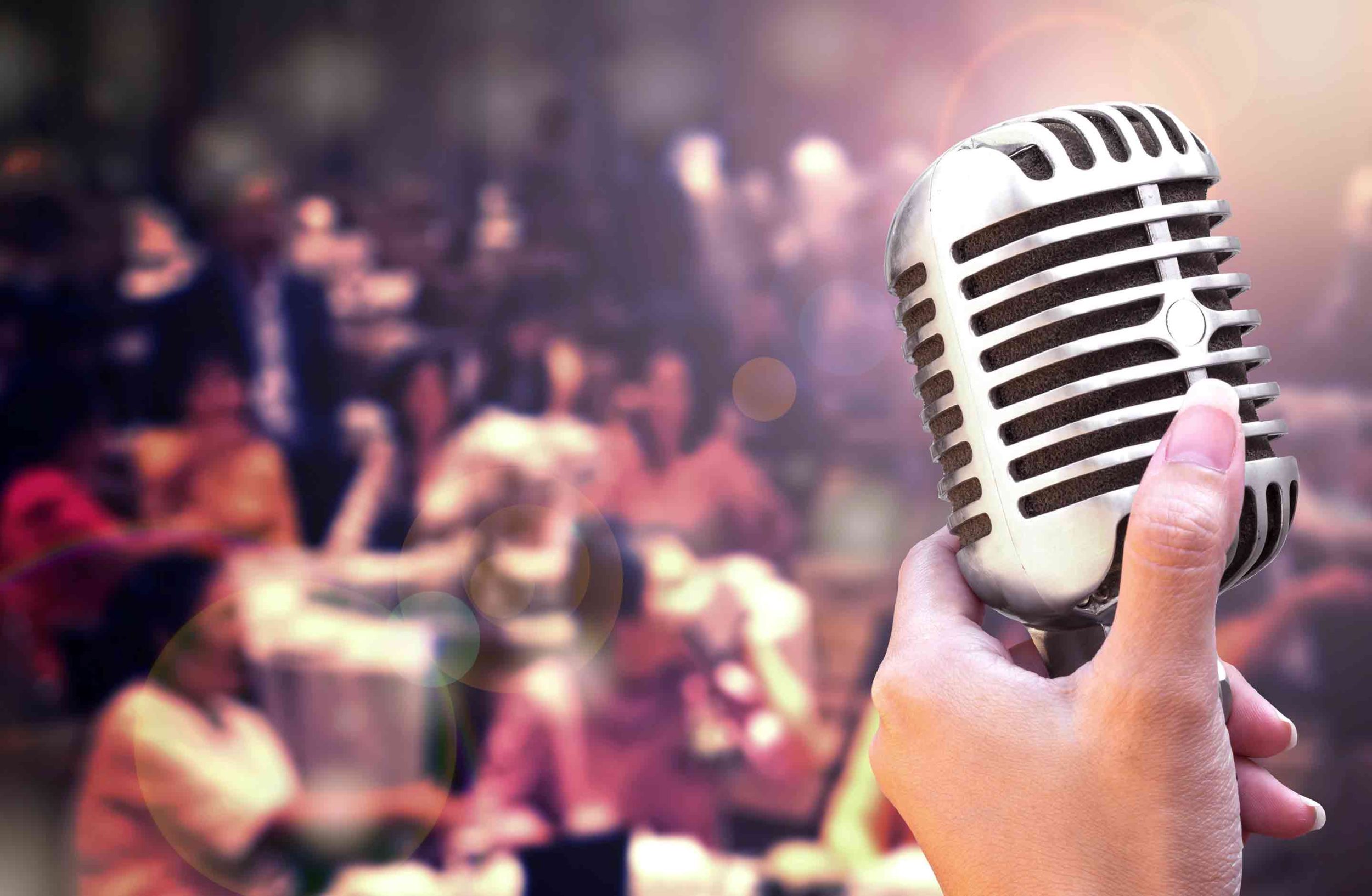 A stand up mic and audience during a comedy dinner show.