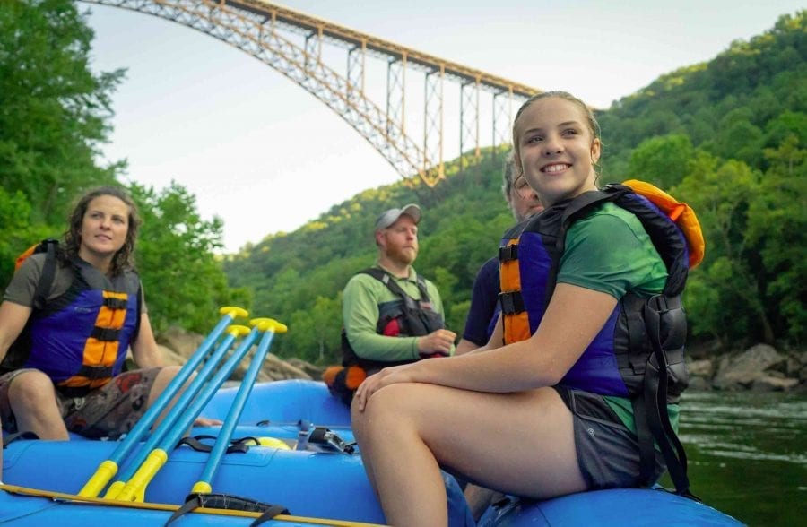 Family rafting in front of the new River gorge bridge