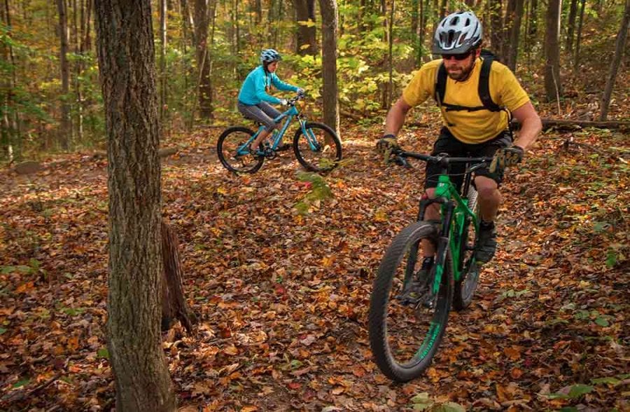 A couple enjoys a mountain biking ride through the woods at ace, the perfect romantic getaway for outdoor lovers.