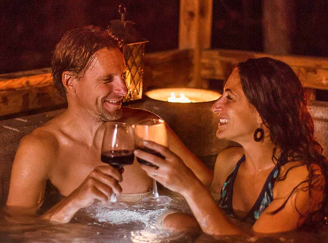 A couple enjoys a cabin hot tub at ACE during the winter in West Virginia.