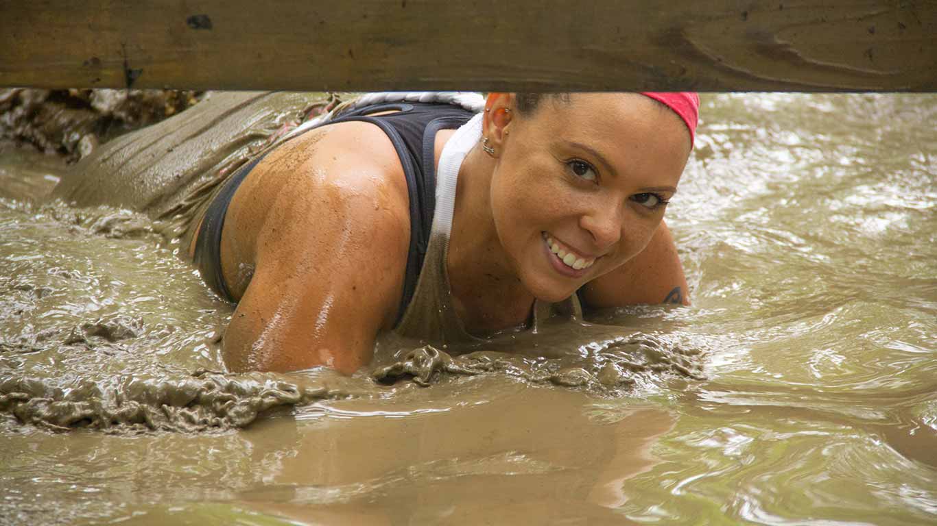 Guest smiling while participating in Gritty Chix Mud Run