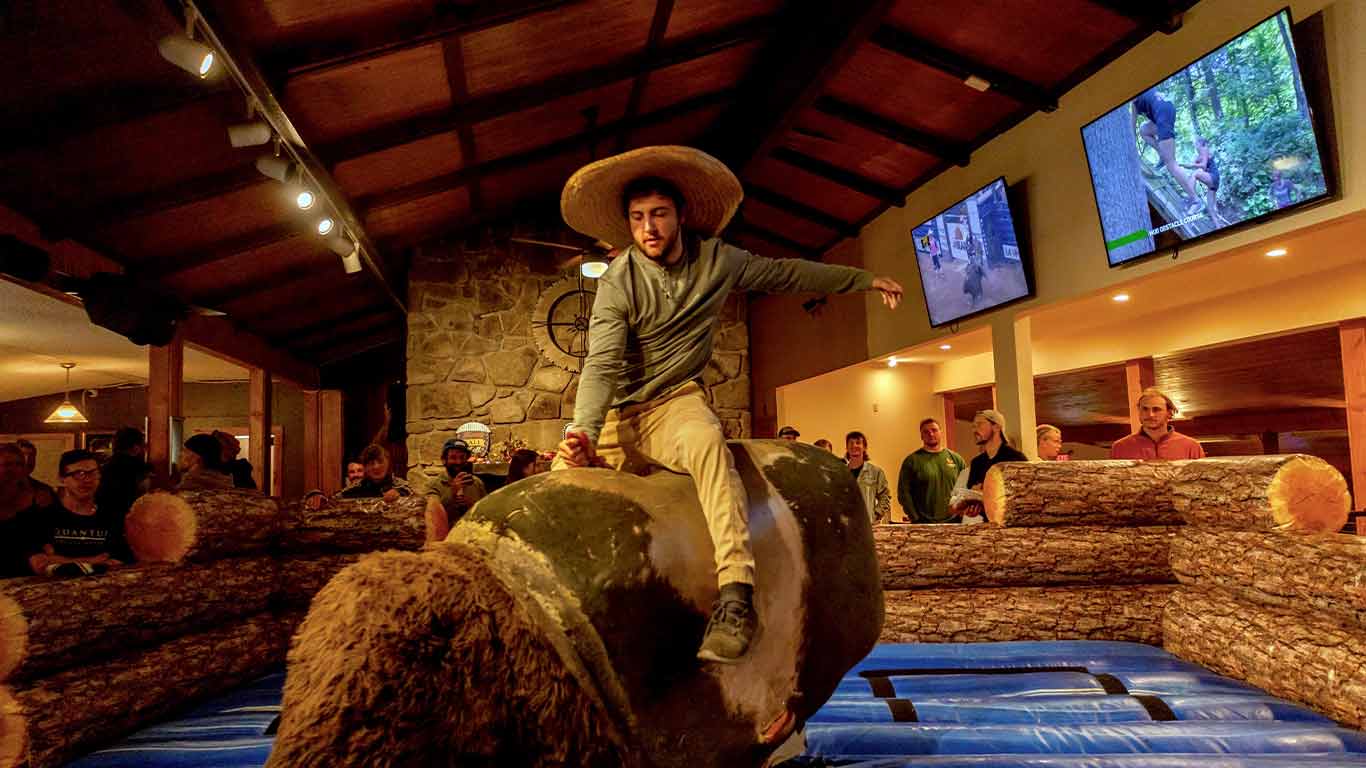 Participant riding the mechanical bull at Cowboy Country Night