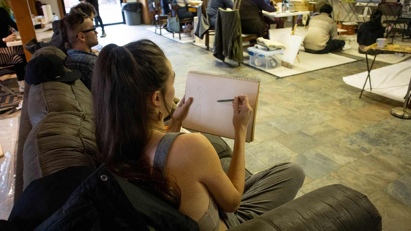 Artist with sketch book at Pigment Sanctuary Art Party